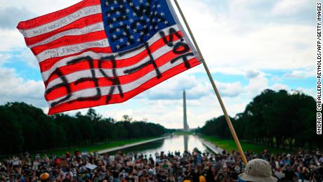 A man waves an American flag with the words &quot;Not Free&quot; on it at a Juneteenth rally in Washington on June 19, 2020. 