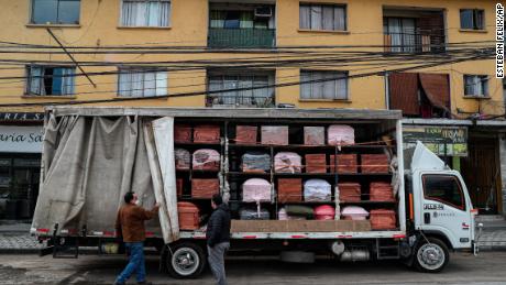 Bergut Funeral Services employees deliver coffins to a funeral store in Santiago, Chile, on  June 19, 2020. Coffin production has increased 120%, according to owner Nicolas Bergerie.