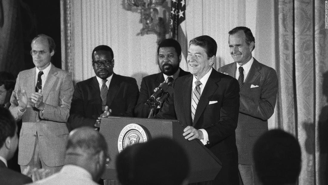 Thomas, second from left, stands with Reagan as the President addressed black appointees at the White House in 1984.