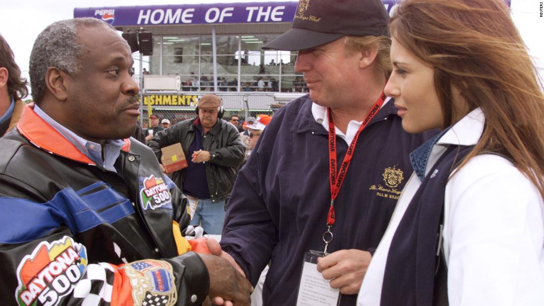 Thomas shakes hands with Donald Trump while serving as the grand marshal for the Daytona 500 in 1999.