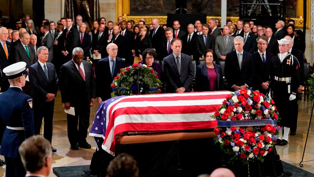 Members of the Supreme Court pause in front of the flag-draped casket of former President George H.W. Bush as he lies in state at the US Capitol Rotunda in 2018.
