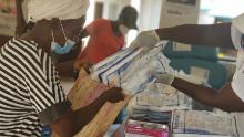A Red Cross volunteer helps prepare packs of treated bed nets to be distributed to community members in Sierra Leone.