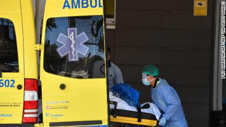 A medical worker lifts a patient out of an ambulance at a hospital in Lleida, northeastern Spain, on July 4, 2020. 