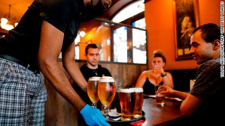 A member of staff serves customers at a pub in Stratford, east London.