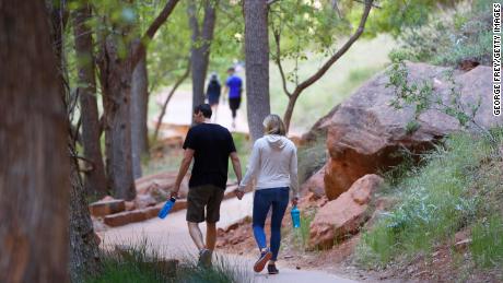 Hikers walking along a paved trail in Utah's Zion National Park, Utah, which had been closed due to the pandemic.