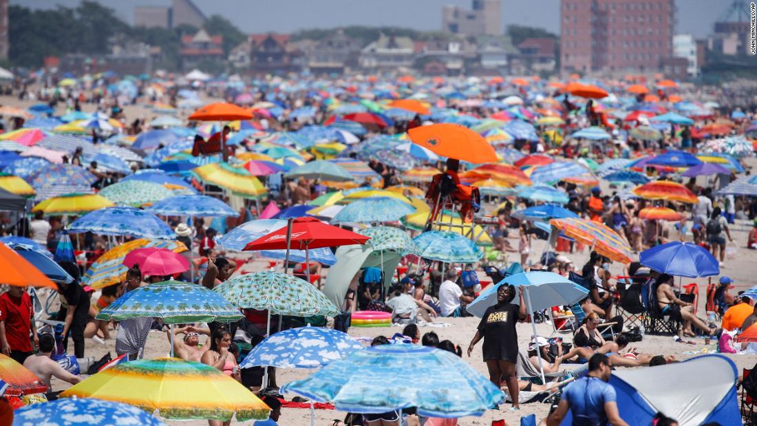 People crowd the beach at Coney Island in Brooklyn, New York.