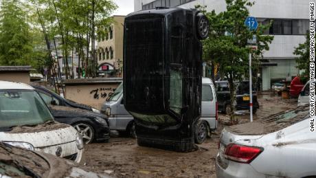 A car stands on its front after being upturned by flooding after the nearby Kuma River burst its banks, on July 5 in Hitoyoshi, Japan.