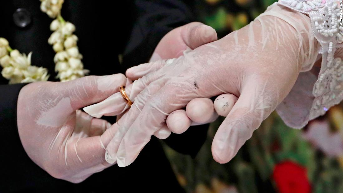 Octavianus Kristianto puts a ring on his new bride, Elma Divani, during their wedding ceremony in Pamulang, Indonesia, on June 19. They were wearing latex gloves to prevent the spread of the coronavirus.