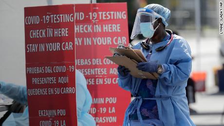 A health care worker carries a stack of clipboards at a COVID-19 testing site sponsored by Community Heath of South Florida at the Martin Luther King, Jr. Clinica Campesina Health Center, during the coronavirus pandemic, Monday, July 6, 2020, in Homestead, Fla. (AP Photo/Lynne Sladky)