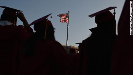 A US flag flies above a building as students earning degrees at Pasadena City College participate in the graduation ceremony, June 14, 2019, in Pasadena, California. 