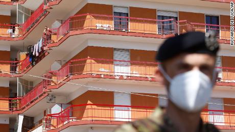 A soldier stands in front of a building where dozens of Covid-19 cases were registered among a community of farm workers, in Mondragone, in the southern Italian region of Campania.