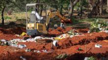 A backhoe has been brought in to dig more graves at the Vila Formosa cemetery in São Paulo.
