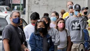Customers wear masks as they wait to enter the first Starbucks store, which is a popular tourist destination, Tuesday, July 7, 2020, at Pike Place Market in Seattle. Tuesday was the first day of a new statewide order that requires people to wear masks or other facial coverings inside businesses in hopes of slowing the spread of the coronavirus. Business owners who fail to refuse service to customers who don't wear masks can face fines or lose their business license, but some business owners have raised concerns about turning away customers. (AP Photo/Ted S. Warren)