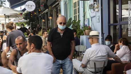 Un homme portant un masque de protection dans un restaurant bondé à Jaffa, Israël, le 29 mai.
