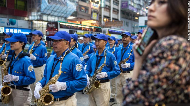 A woman watches as supporters of the Falun Gong spiritual group, banned in mainland China, take part in a march in Hong Kong on April 27, 2019, to observe the 20th anniversary of a large demonstration in Beijing which led to a crackdown against the movement.