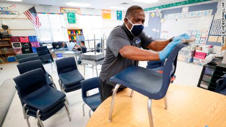 Tracy Harris, custodio de las Escuelas Públicas de Des Moines, limpia las sillas en un salón de clases en la Escuela Primaria Brubaker.