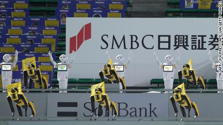 SoftBank Corp&#39;s humanoid robots Pepper (white) and Boston Dynamics&#39; robots SPOT (yellow) dance and sing before the Nippon Professional Baseball league match between SoftBank Hawks and Rakuten Golden Eagles in Fukuoka on July 10, 2020. (Photo by STR / JIJI PRESS / AFP) / Japan OUT (Photo by STR/JIJI PRESS/AFP via Getty Images)