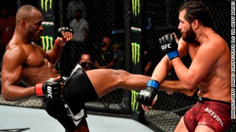 Kamaru Usman, left, kicks Jorge Masvidal in their title bout at UFC 251. 