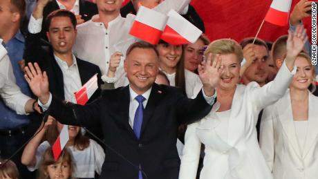 Incumbent President Andrzej Duda, left, and his wife Agata Kornhauser-Duda wave to supporters in Pultusk, Poland, Sunday, July 12, 2020. An exit poll in Poland&#39;s presidential runoff election shows a tight race that is too close to call between the conservative incumbent, Andrzej Duda, and the liberal Warsaw mayor, Rafal Trzaskowski. (AP Photo/Czarek Sokolowski)