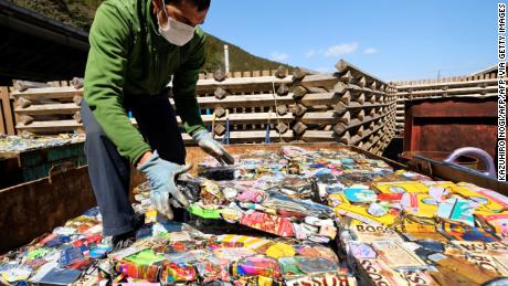 Un residente apila láminas de latas de aluminio comprimido en un centro de residuos en Kamikatsu, Prefectura de Tokushima.