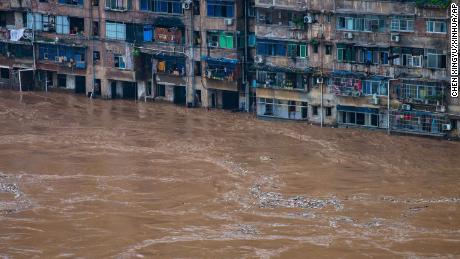Floodwaters 1 Temmuz'da Çin'in güneybatısındaki Chongqing'de bir konut binasının önünden geçiyor.
