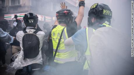 A journalist raises his hands after police fire tear gas on October 1, 2019 in Hong Kong. Pressure has been growing on reporters in the city under a new security law. 