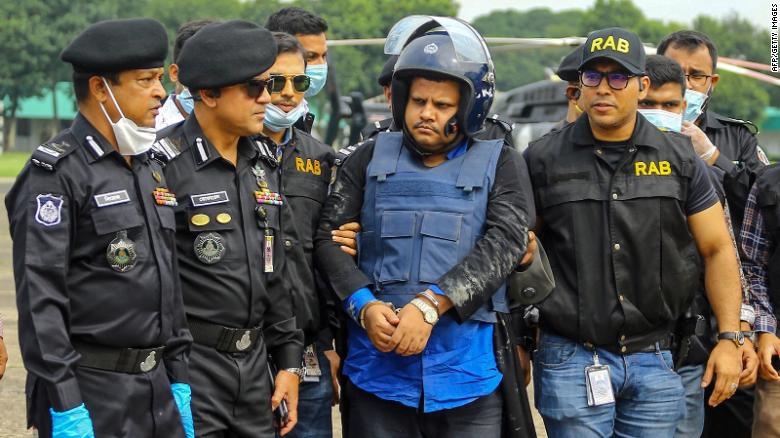 Bangladeshi security personnel escort Mohammad Shahed (center)  in Dhaka following his arrest.