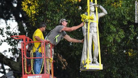 A Confederate statue on campus is lowered as part of relocation process earlier this month. 