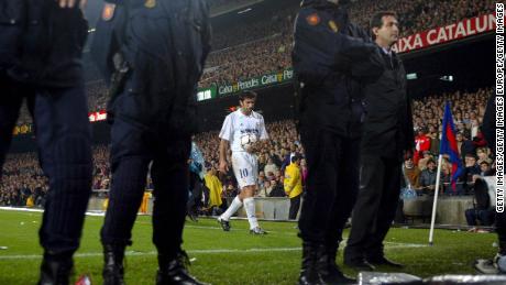 Luis Figo of Real Madrid prepares to take a corner with a police escort during the La Liga match between FC Barcelona and Real Madrid played at the Nou Camp Stadium, on November 23, 2002. 