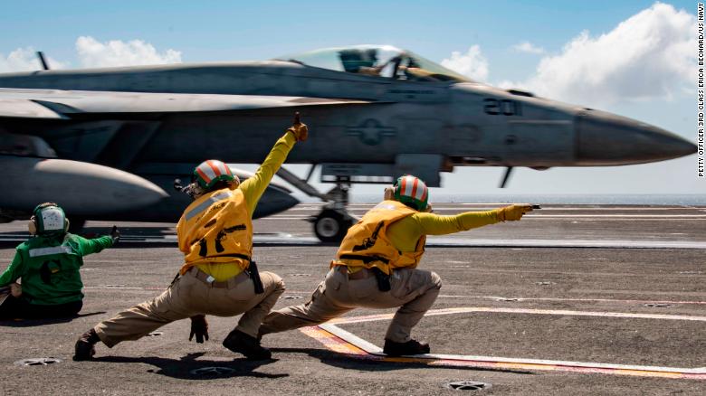 Sailors signal an F/A-18E Super Hornet to launch from the flight deck of the USS Ronald Reagan during flight operations in the Indian Ocean.