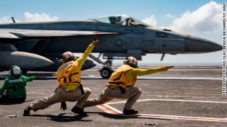 Sailors signal an F/A-18E Super Hornet to launch from the flight deck of the USS Ronald Reagan during flight operations in the Indian Ocean. 