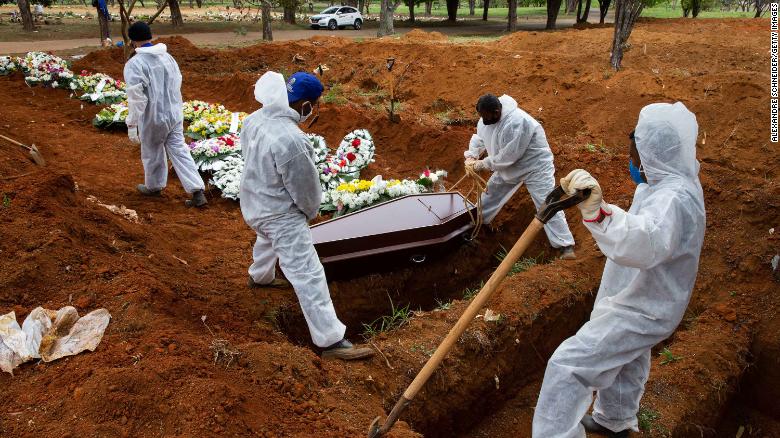Workers bury a victim of the coronavirus at the Vila Formosa cemetery in Sao Paulo on Thursday.