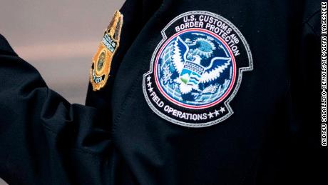 A Customs and Border protection officer checks her phone in the terminal at Dulles International airport in Dulles, Virginia on March 17, 2020.