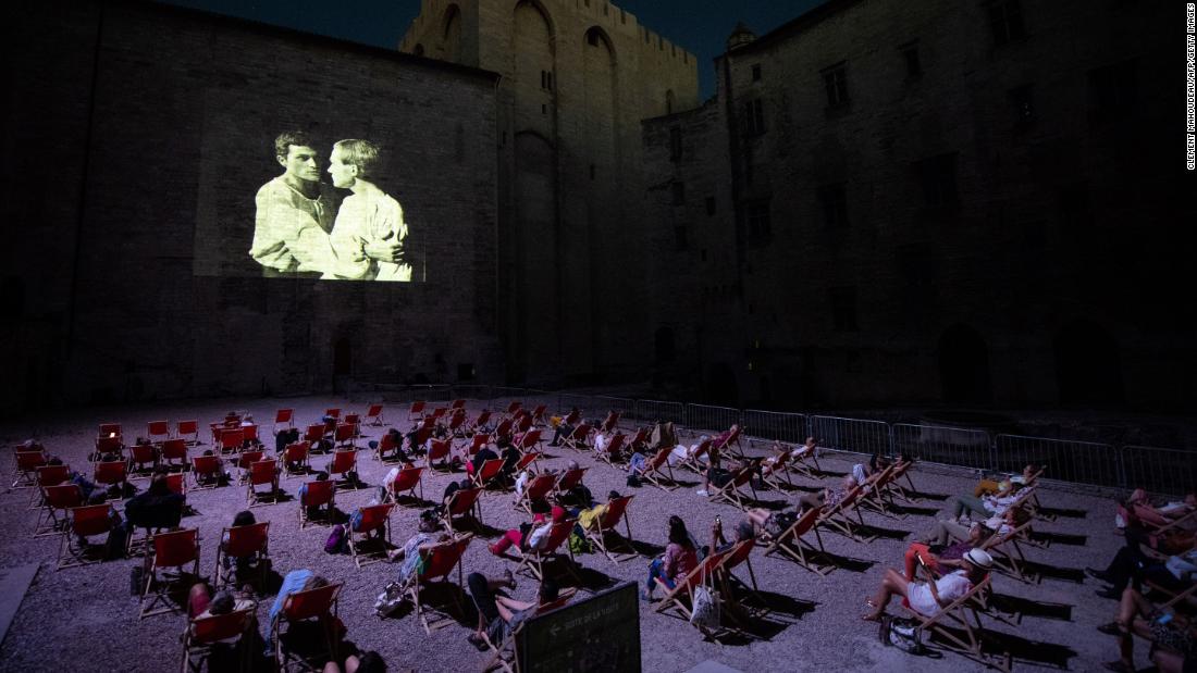 People watch a video projection in Avignon, France, on July 18. Since the Avignon Theatre Festival has been canceled because of the coronavirus pandemic, the festival's organization has been projecting plays that made its history.
