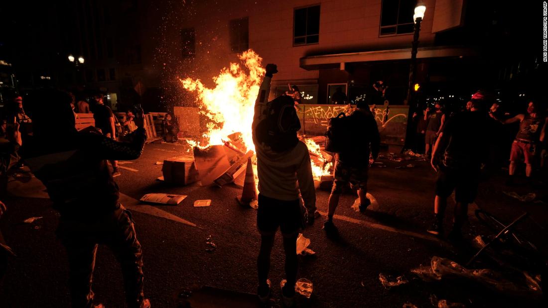 Protesters start a fire in the street on May 29.