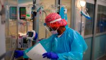 Registered Respiratory Therapist Niticia Mpanga walks into a Covid patients room in the ICU at Oakbend Medical Center in Richmond, Texas, on July 15, 2020. -The latest modeling projects the number of COVID-19 deaths in the US to increase further, even as one research team suggests the near-universal use of masks could save 40,000 lives between now and November (Photo by Mark Felix/AFP/Getty Images)