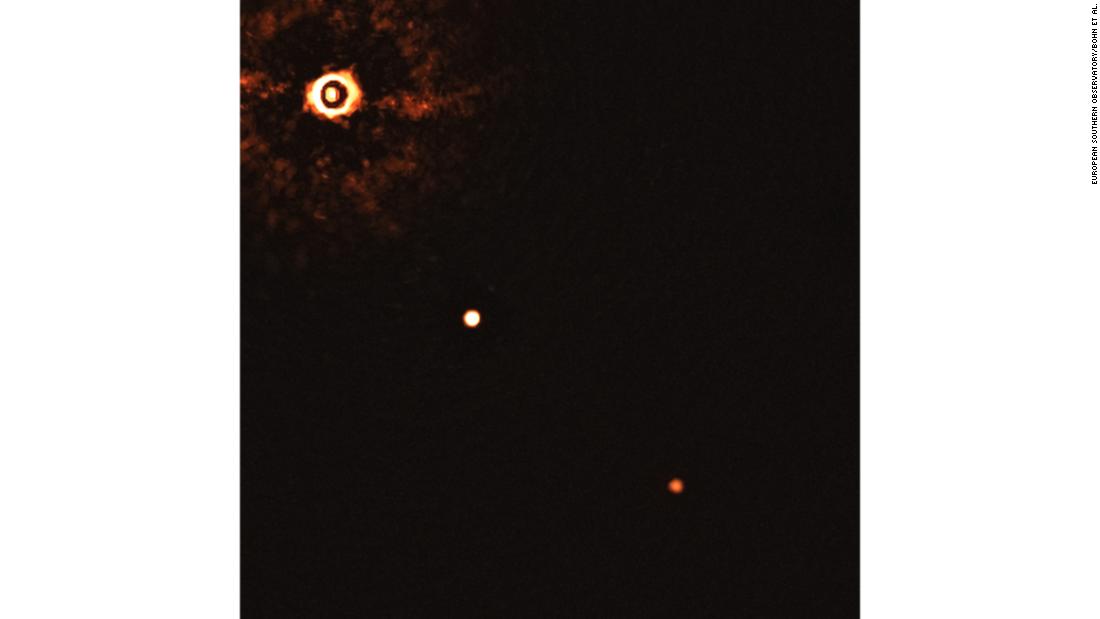 This image shows a young sun-like star being orbited by two gas giant exoplanets. It was taken by the SPHERE instrument on European Southern Observatory&#39;s Very Large Telescope. The star can be seen in the top left corner, and the planets are the two bright dots.