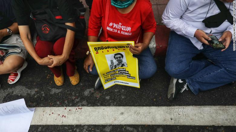 A woman holds a poster featuring missing pro-democracy activist Wanchalearm Satsksit during a demonstration in front of the army headquarters in Bangkok on July 20, 2020. 