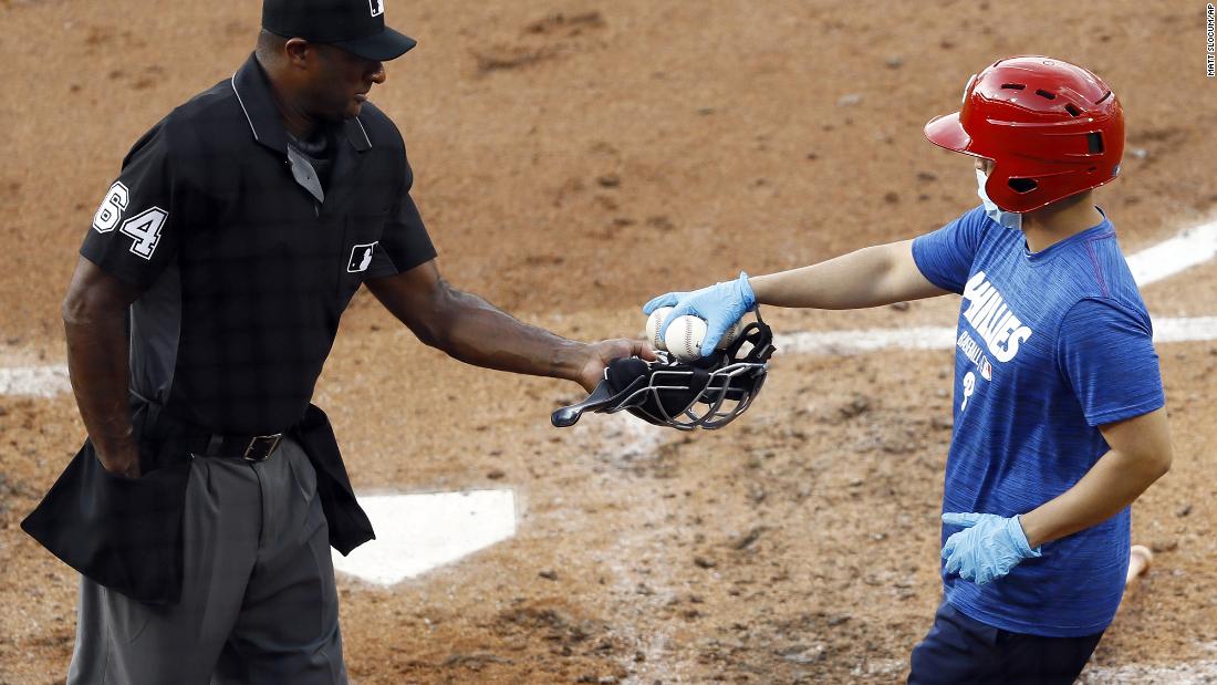 Umpire Alan Porter receives baseballs from a Philadelphia Phillies bat boy during a team scrimmage on July 14.