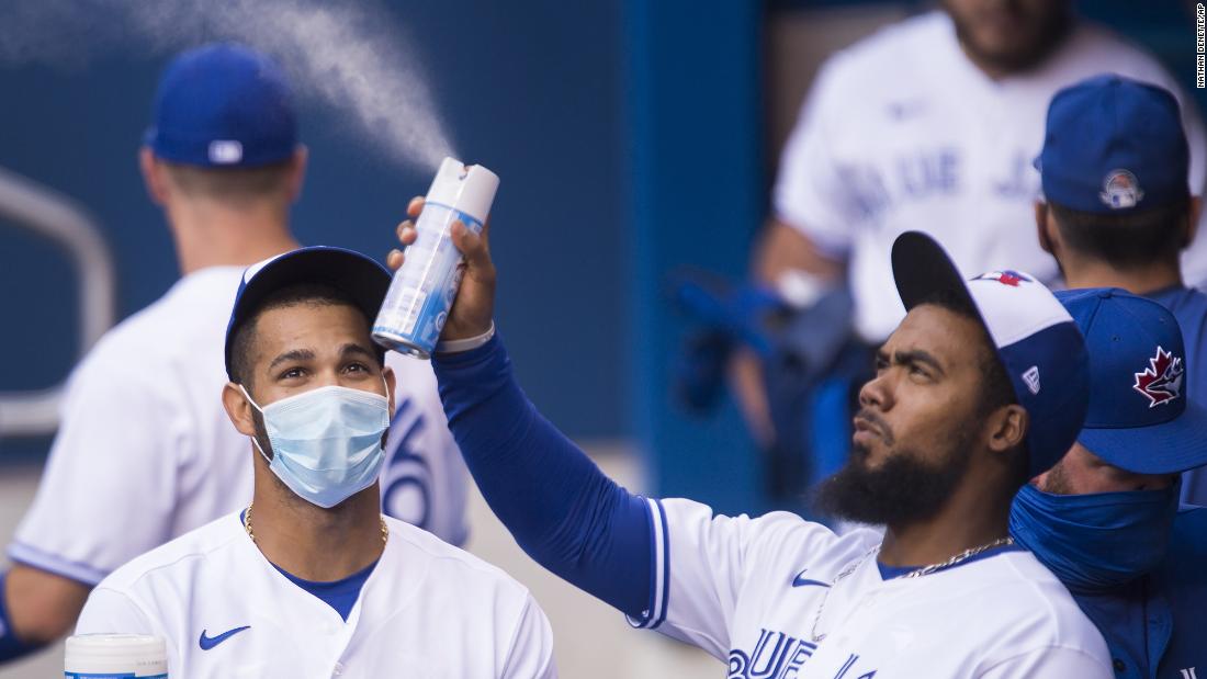 Toronto&#39;s Teoscar Hernandez sprays sanitizer in the dugout during an intrasquad game on July 17.