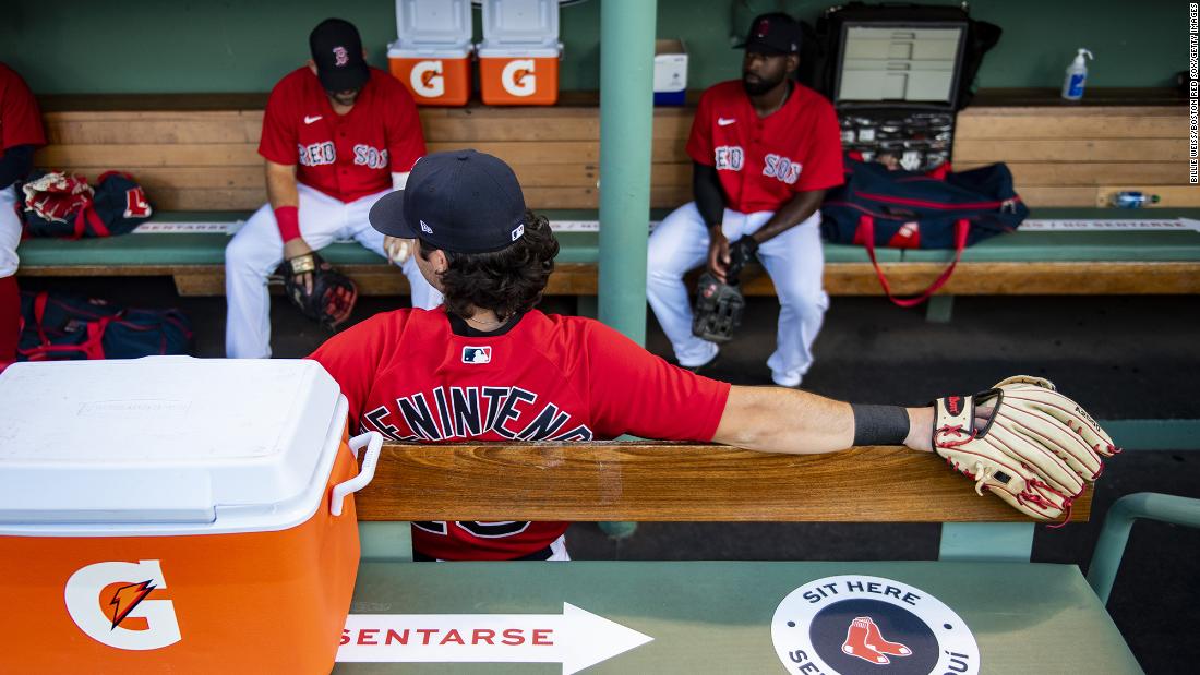 Members of the Boston Red Sox sit apart from one another in a Fenway Park dugout before scrimmaging Toronto on Tuesday, July 21.