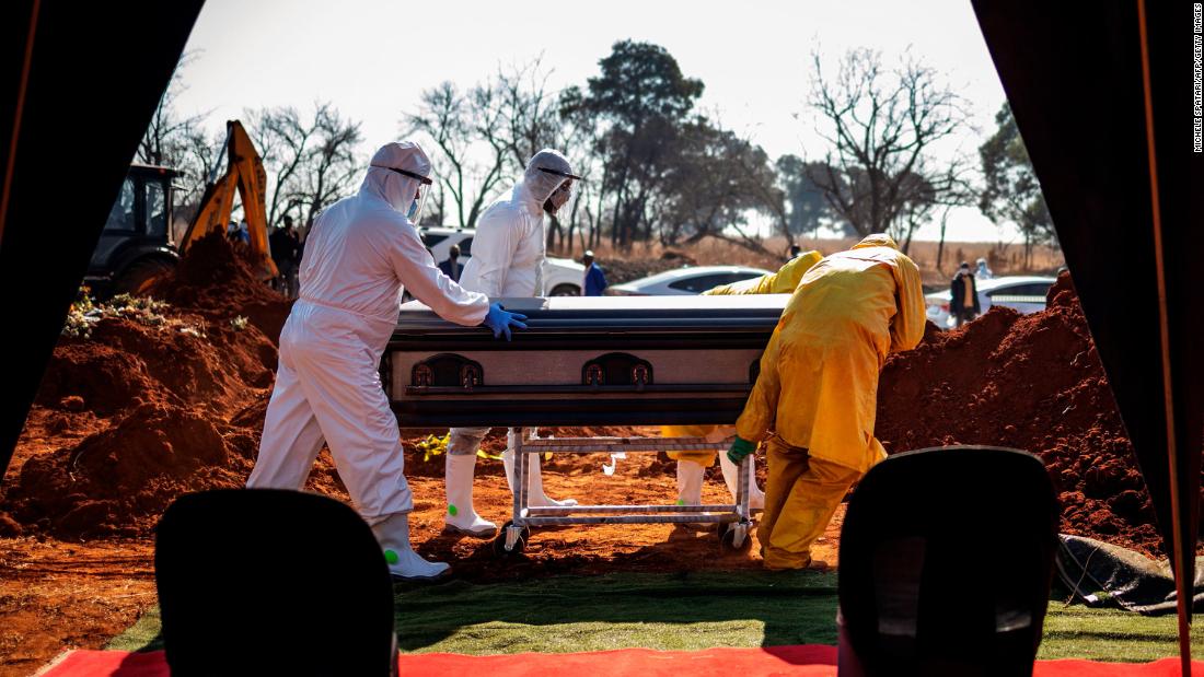 Undertakers push the casket of a coronavirus victim during a funeral in Soweto, South Africa, on July 21.