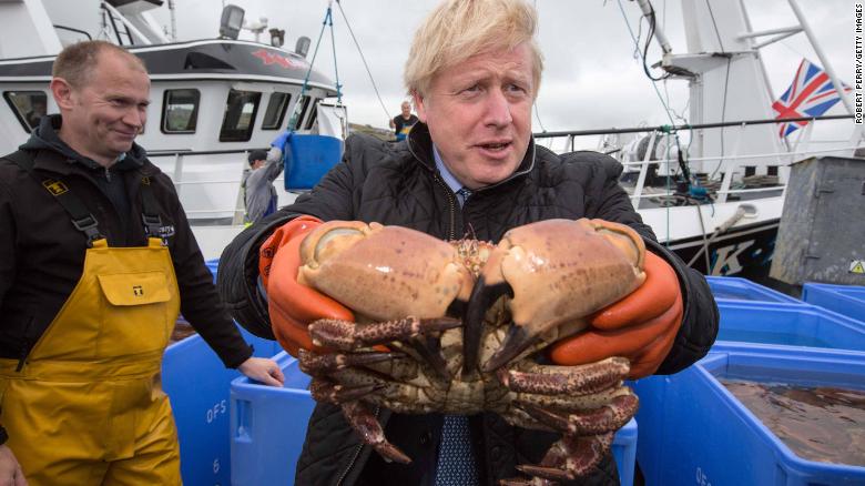 British Prime Minister Boris Johnson holds a crab at Stromness Harbour, Orkney.