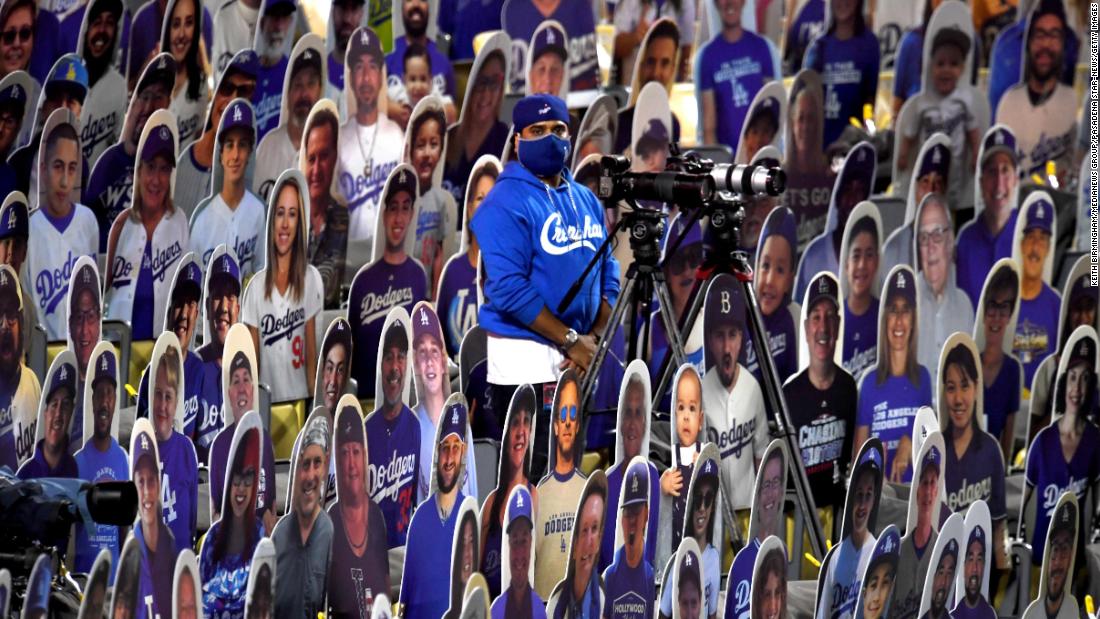 A camera operator stands in the middle of fan cutouts in Los Angeles.