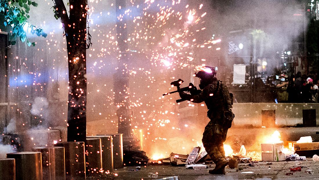 A federal officer fires crowd-control munitions at demonstrators on July 24.