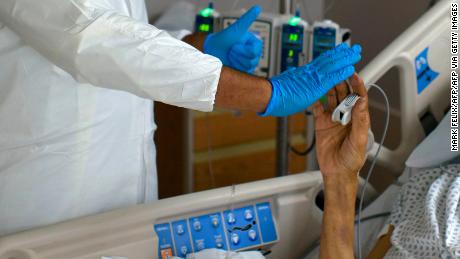 A healthcare worker high-fives a patient in the Covid-19 Unit at United Memorial Medical Center in Houston, Texas, July 2, 2020. - Despite its renowned medical center with the largest agglomeration of hospitals and research laboratories in the world, Houston is on the verge of being overwhelmed by cases of coronavirus exploding in Texas. (Photo by Mark Felix / AFP) / RESTRICTED TO EDITORIAL USETO GO WITH AFP STORY by Julia Benarrous: &quot;Covid-19: Houston&#39;s hospital system underwater&quot; (Photo by MARK FELIX/AFP via Getty Images)