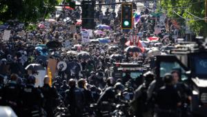 Police clash with protesters Saturday, July 25, 2020, during a Black Lives Matter protest near the Seattle Police East Precinct headquarters in Seattle. A large group of protesters were marching Saturday in Seattle in support of Black Lives Matter and against police brutality and racial injustice. (AP Photo/Ted S. Warren)