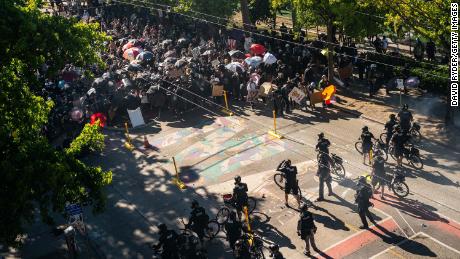 Police push demonstrators back atop a Black Lives Matter street mural in the area formerly known as CHOP during protests in Seattle on Saturday, July 25.