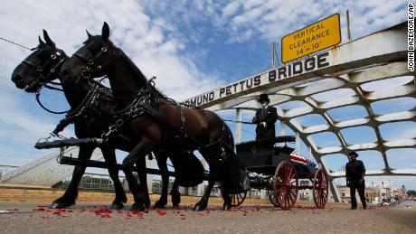 The casket of Rep. John Lewis moves over the Edmund Pettus Bridge by horse drawn carriage during a memorial service for Lewis on Sunday in Selma, Alabama.