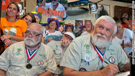 In this handout photo provided by the Florida Keys News Bureau, previous Ernest Hemingway look-alike winners including Chris Storm, left, and John Stubbings, right, eye contestants in the 2015 &quot;Papa&quot; Hemingway Look-Alike Contest at Sloppy Joe&#39;s Bar in Key West, Florida. 